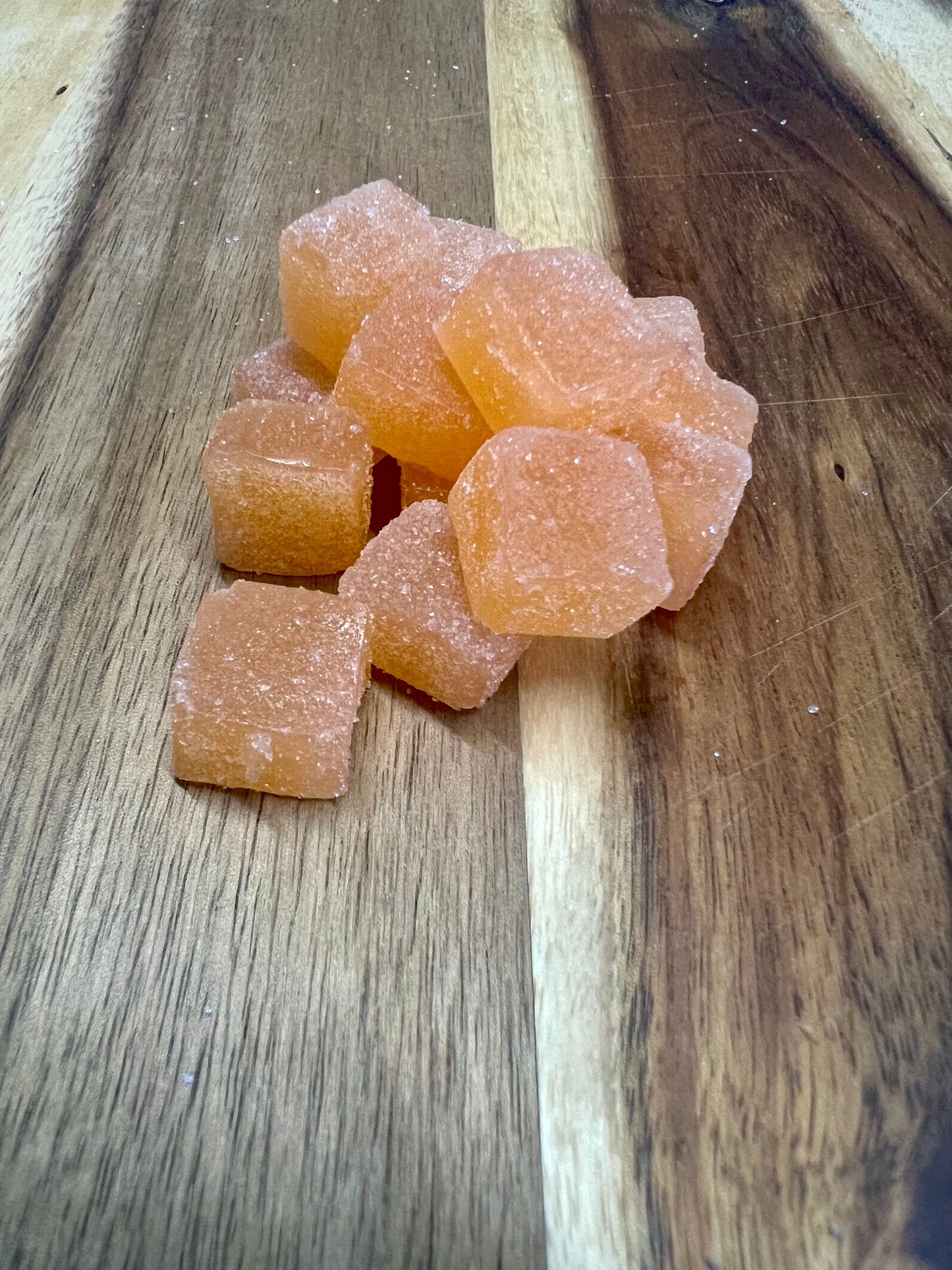 peach CBN and cbd gummies on wooden plank